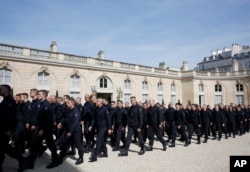 Emergency service personnel walk at the Elysee Palace in Paris after a meeting with French President Emmanuel Macron, April 18, 2019.