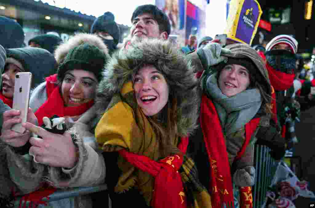 Para pengunjung berkumpul di Times Square di New York untuk menyaksikan naiknya bola penanda perayaan Tahun Baru ke puncak tiang, 31 Desember 2017.