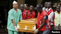 FILE - Mortuary workers and Kenya Red Cross volunteers carry the coffin April 8, 2015, containing the body of a student killed during an attack by gunmen at Garissa University in Kenya.