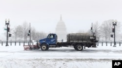 Xe ủi tuyết đi phía trước điện Capitol tại thủ đô Washington, ngày 2/3/2014.