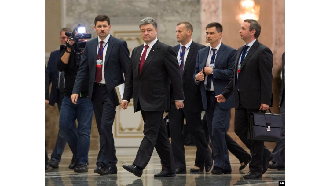 Ukrainian President Petro Poroshenko, center, leaves the hall after meeting with Russian President Vladimir Putin in Minsk, Belarus, Aug. 26, 2014.