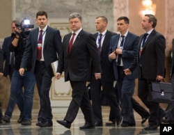 Ukrainian President Petro Poroshenko, center, leaves the hall after meeting with Russian President Vladimir Putin in Minsk, Belarus, Aug. 26, 2014.