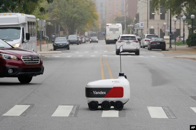 A food delivery robot crosses a street in Ann Arbor, Mich. on Thursday, Oct. 7, 2021. (AP Photo/Carlos Osorio)