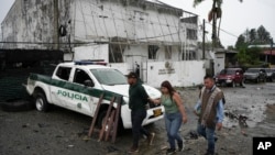 Residentes pasan frente a una comisaría después de un ataque en Morales, Colombia, el 20 de mayo de 2024. Según la policía, dos agentes murieron en el ataque de disidentes de las Fuerzas Armadas Revolucionarias de Colombia (FARC), conocidas como FARC-EMC.