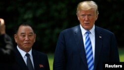 Presiden Amerika Donald Trump berpose dengan utusan Korea Utara Kim Yong Chol (kiri) setelah pertemuan di Gedung Putih, hari Jumat (1/6),