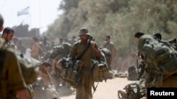 Yon sòlda izrayelyen, manm brigad Givati, ak zam li sou zepòl li apre li fin kite Gaza pou l retounen ann Izrayèl. (Foto: 4 out 2014).
