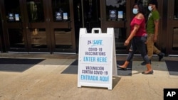 FILE - Masked students walk to the COVID-19 vaccination site at the Rose E. McCoy Auditorium on the Jackson State University campus in Jackson, Miss., July 27, 2021.