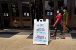 FILE - Masked students walk to the COVID-19 vaccination site at the Rose E. McCoy Auditorium on the Jackson State University campus in Jackson, Miss., July 27, 2021.
