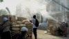 Protesters stand behind a barricade at Sanchaung district in Yangon, Myanmar, March 8, 2021. 