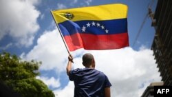 FILE - A man waves a Venezuelan flag in Caracas on Aug. 17, 2024. 