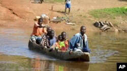 Des réfugiés ivoiriens traversent la rivière Cestos dans la ville frontalière libérienne de Butuo, en Côte d’Ivoire, le 19 novembre 2004. 