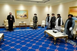 FILE - U.S. Secretary of State Mike Pompeo, left, meets with the Taliban's Mullah Abdul Ghani Baradar, center right, and members of his negotiating team, in Doha, Qatar, Nov. 21, 2020.