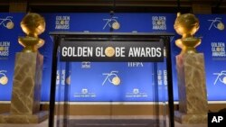 Two Golden Globes statues flank the podium prior to the nominations for 75th annual Golden Globe Awards at the Beverly Hilton hotel in Beverly Hills, Calif., Dec. 11, 2017.