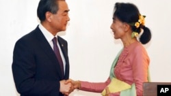 Leader of the National League for Democracy party (NLD) and Myanmar's new foreign minister, Aung San Suu Kyi, shakes hands with Chinese Foreign Minister Wang Yi, left in Naypyitaw, Myanmar, April 5, 2016. 