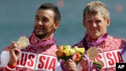 Russia's Yury Postrigay, right, and Alexander Dyachenko, left, show the gold medals they won in the men's kayak double 200m in Eton Dorney, near Windsor, England, at the 2012 Summer Olympics, Aug. 11, 2012. Dyachenko was among the five canoeists named in a recent report in 2016 by the World Anti-Doping Agency, alleging a state-sponsored doping cover-up.