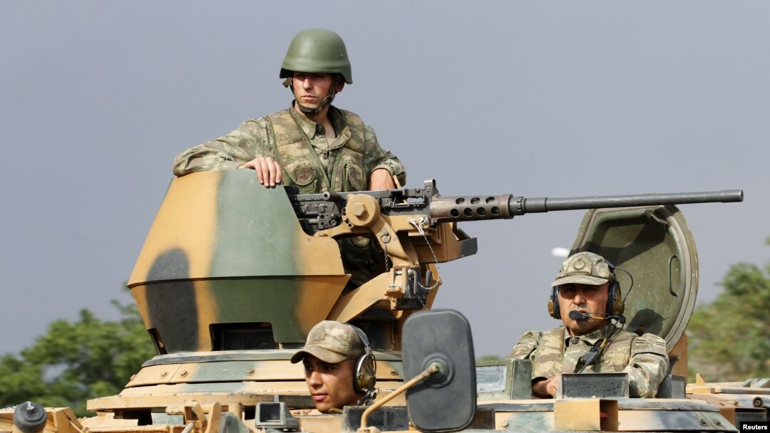 Turkish soldiers are seen on an armoured personnel carrier as part of a Turkish military convoy travelling on a main road leading to the southeastern Turkish city of Kilis July 30, 2012