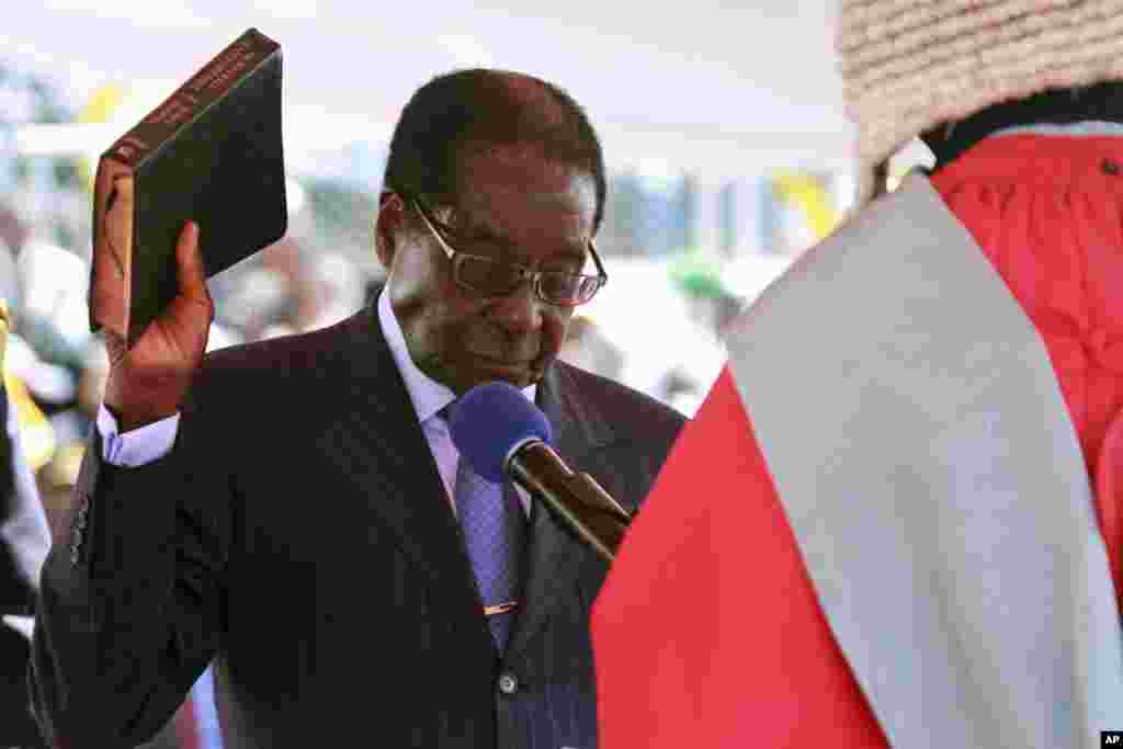 President Robert Mugabe wa Zimbabwe ashika bibilia akila kiapu wakati wa sherehe za kuapishwa kwake mjini Harare, Ogusti 22, 2013.