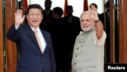 Presiden China Xi Jinping (kiri) dan dan PM India Narendra Modi sebelum melakukan pertemuan di Ahmedabad, India (17/9).