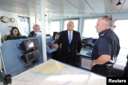 FILE - British Home Secretary Sajid Javid, center, meets Border Force staff on board the HMC Searcher in Dover, Britain, Jan. 2, 2019.