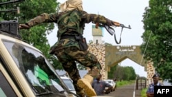 A fighter jumps off a vehicle moving in a military convoy accompanying the governor of Sudan's Darfur State during a stopover at Gedaref University in the eastern city of Gedaref while on the way to Port Sudan on Aug.30, 2023.