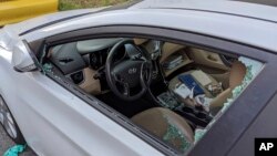 This Thursday, May 21, 2020, photo shows a parked car with a broken driver's side window after a smash-and-grab break-in in Los Angeles. The coronavirus hasn't been kind to car owners. (AP Photo/Damian Dovarganes)