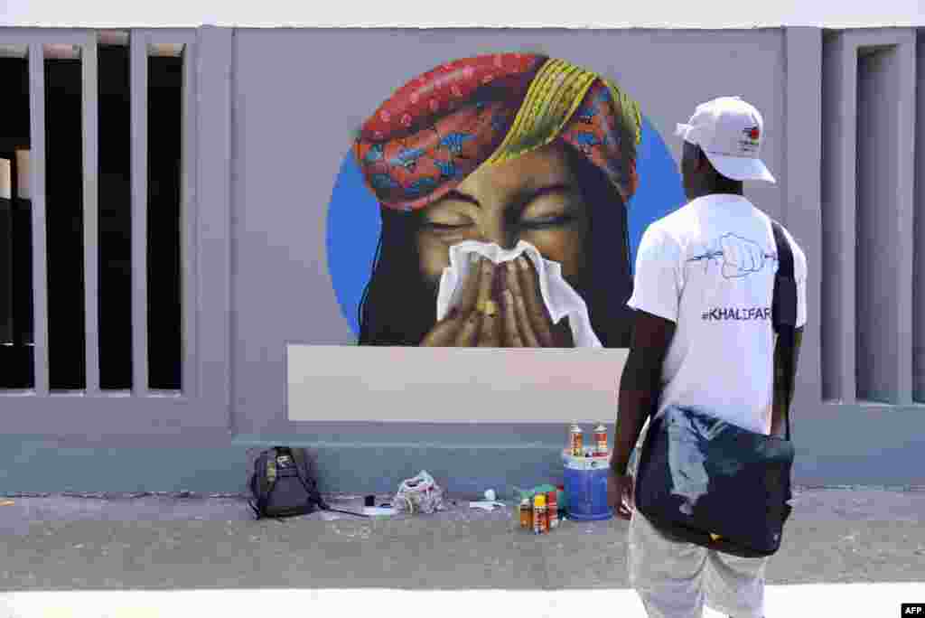 سینیگال کی ایک دیوار پر بنا خاکہ جس میں پیغام دیا گیا ہے کہ کھانستے ہوئے منہ پر رومال لازمی رکھیں۔ &nbsp; &nbsp; 