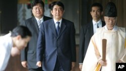 Japanese Prime Minister, Shinzo Abe is led by a Shinto priest during his visit to the Yasukuni shrine in 2005 where Japan's war dead including high-ranking war criminals have been enshrined. (File Photo)