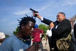 Ruling party Senator Ralph Fethiere fires his gun outside parliament in Port-au-Prince, Haiti, Sept. 23, 2019.