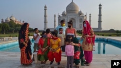 A group of Indians who visited the Taj Mahal monument that was Wednesday reopened to public after the lockdown to curb the spread of coronavirus gather to get photographed in Agra, India, June 16, 2021.