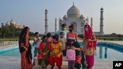 A group of Indians who visited the Taj Mahal monument that was Wednesday reopened to public after the lockdown to curb the spread of coronavirus gather to get photographed in Agra, India, June 16, 2021.