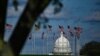 FILE - The dome of the U.S. Capitol building is seen behind a row of U.S. flags in Washington, April 10, 2020.