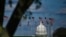 FILE - The dome of the U.S. Capitol building is seen behind a row of U.S. flags in Washington, April 10, 2020.