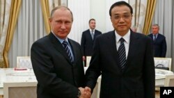 8일 러시아 모스크바를 방문한 리커창 중국 총리(오른쪽)가 블라디미르 푸틴 러시아 대통령과 만나 악수하고 있다.