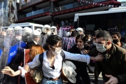 Turkish police officers, in riot gear, and wearing face masks for protections against the spread of the coronavirus, scuffle with protesters during a demonstration in Istanbul, Tuesday, June 2, 2020, against the recent killing of George Floyd in…