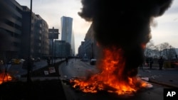 Smoke billows over burning barricades in front of the new ECB headquarters in Frankfurt, Germany, Wednesday, March 18, 2015.