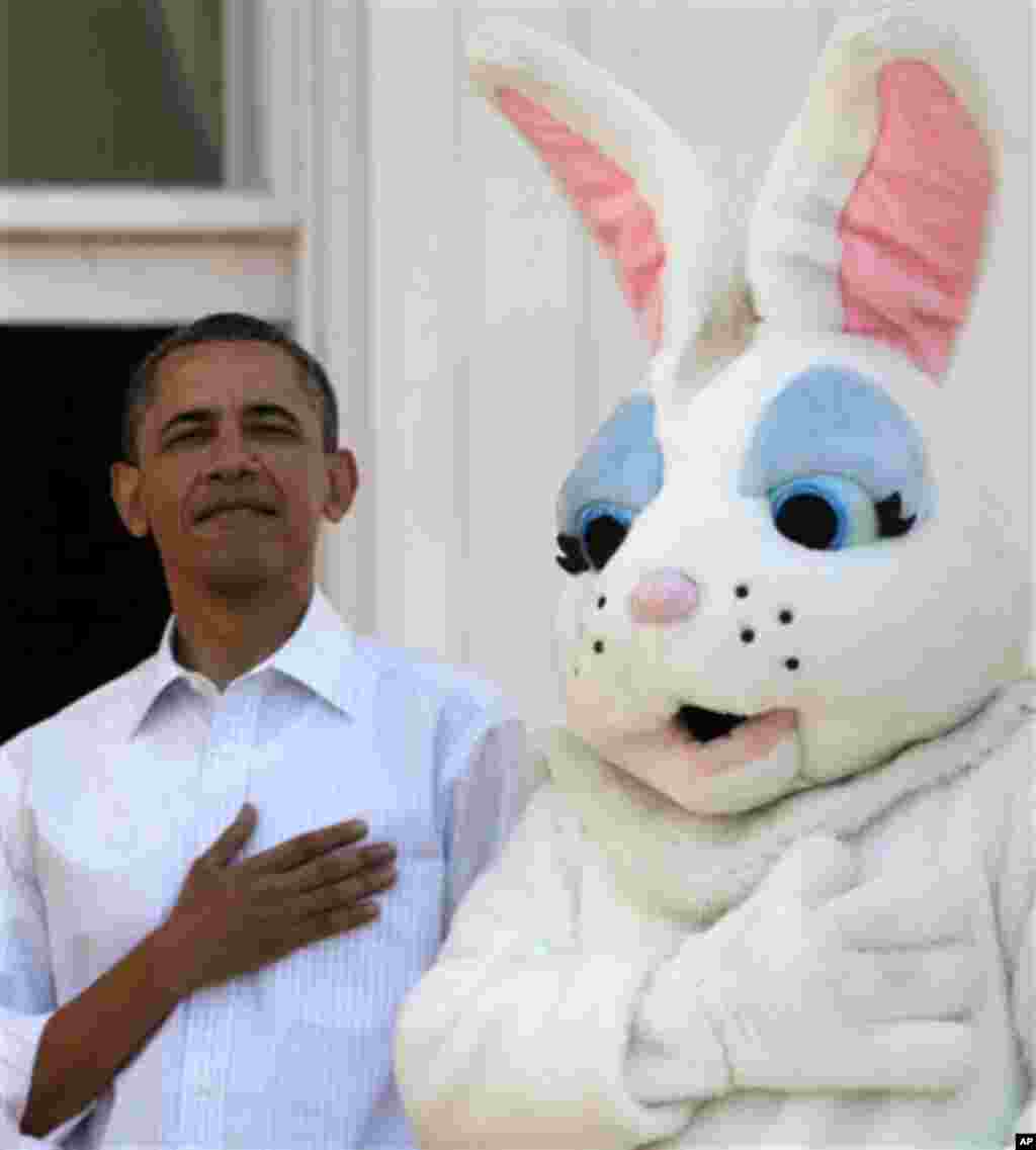 President Barack Obama stands next to the Easter Bunny during the singing of the National Anthem, at the White House in Washington, Monday, April 9, 2012, during the annual Easter Egg Roll. (AP Photo/Carolyn Kaster)