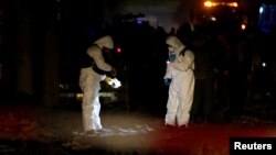 Afghan officials investigate at the site of a bomb blast in Kabul, Afghanistan, March 13, 2017.