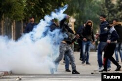 A Palestinian protester hurls back a tear gas canister fired by Israeli troops during clashes at a protest against U.S. President Donald Trump's decision to recognize Jerusalem as the capital of Israel, in the West Bank city of Bethlehem Dec. 7, 2017.
