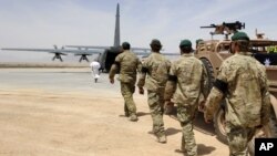 Anggota pasukan khusus ISAF mengantarkan peti jenazah tentara Australia yang terbunuh dalam operasi khusus kerjasama ISAF-Polisi Afghanistan menuju pesawat C-130 di bandara militer Tarin Kot, Uruzgan, Afghanistan, 28 Mei 2011 (Foto: dok). Australia menarik pasukan tempur terakhirnya dari Afghanistan, Senin (16/12).