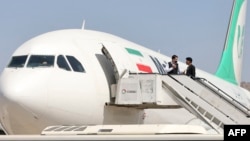 FILE - Passengers get off from a privately owned Iranian airline Mahan Air flight at the airport in Kabul on Sept. 15, 2021