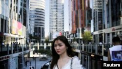 一名年轻女子2018年6月28日在北京三里屯Soho住宅和商业综合体散步。(路透社）