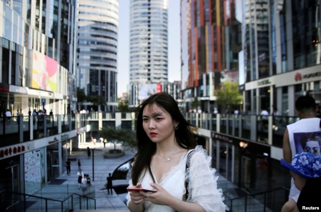 一名年輕女子2018年6月28日在北京三里屯Soho住宅和商業綜合體散步。