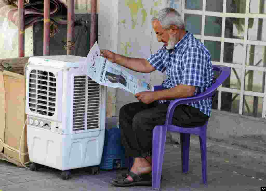 An Iraqi man reads a newspaper with front page headlines reporting U.S. President Barack Obama&#39;s plan to battle Islamic State militants in Baghdad, Sept. 11, 2014.