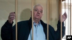 FILE - Norwegian national Frode Berg, who was accused of spying on Russia, stands in a cage in Lefortovo district court in Moscow, Russia, Oct. 1, 2018.