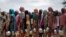FILE - Sudanese women who fled the conflict in Geneina in Sudan's Darfur region, line up to receive rice portions from Red Cross volunteers in Ourang on the outskirts of Adre, Chad July 25, 2023. 