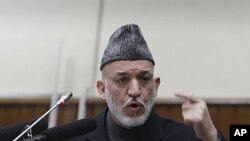 Afghan President Hamid Karzai, right, delivers a speech at the opening of the second year of the Afghanistan parliament in Kabul, Afghanistan, January 21, 2012.