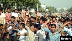 Garment workers shout slogans as they block a street during a protest demanding higher wages in Gazipur, Nov. 13, 2013. 