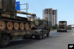 FILE - A convoy of Turkish military trucks carrying tanks destined for Syria, moves near the town of Kilis, Turkey, Sept. 14, 2018.