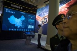 In this Oct. 17, 2017 photo, visitors look at a display of information technologies at an exhibition highlighting China's achievements under five years of Xi's leadership at the Beijing Exhibition Hall.
