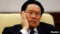 Then China's Public Security Minister Zhou Yongkang reacts as he attends the Hebei delegation discussion sessions at the 17th National Congress of the Communist Party of China at the Great Hall of the People, in Beijing October 16, 2007